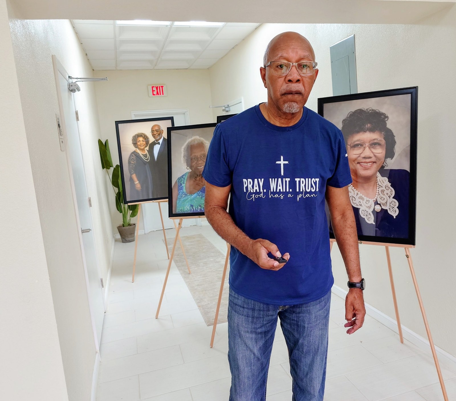 A ministry member standing beside framed family portraits
